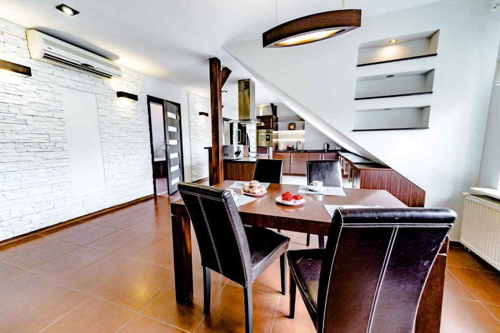 a dining room with a wooden table and black chairs at Apartament Stylowy in Leszno