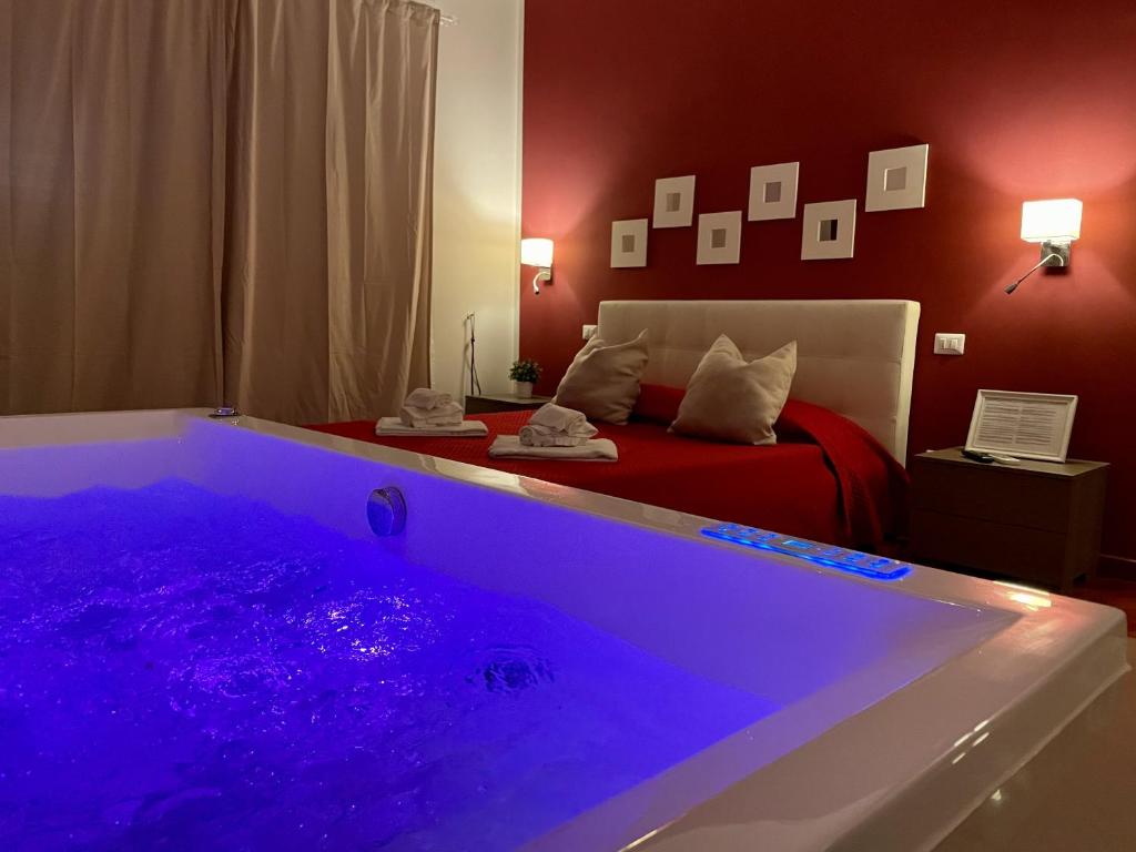 1 dormitorio con bañera grande y cama en Le Coq Suites, en Roma