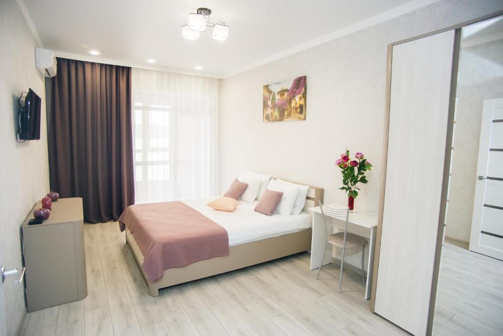 een slaapkamer met een bed, een tafel en een spiegel bij Апарт-отель Кристалл 375 in Novorossiejsk