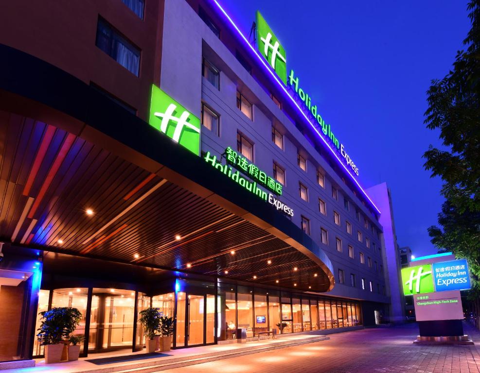 長春市にあるHoliday Inn Express Changchun High-Tech Zone, an IHG Hotelの横にネオンの看板が立つ建物