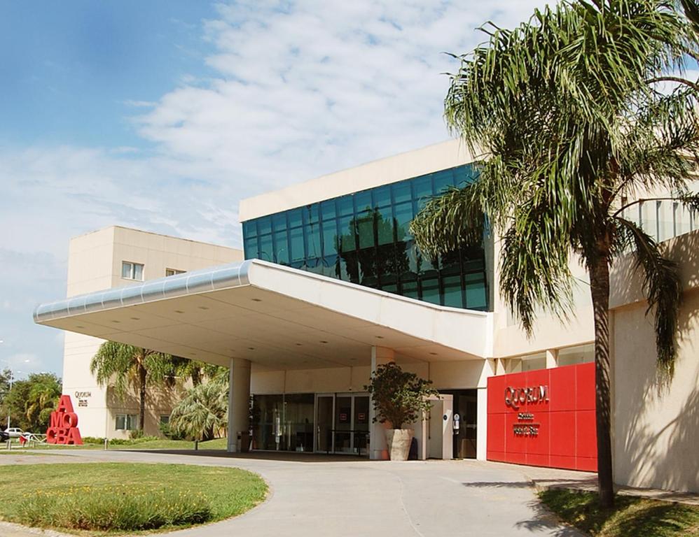 ein Gebäude mit einer Palme davor in der Unterkunft Quorum Córdoba Hotel, Resort Urbano in Cordoba