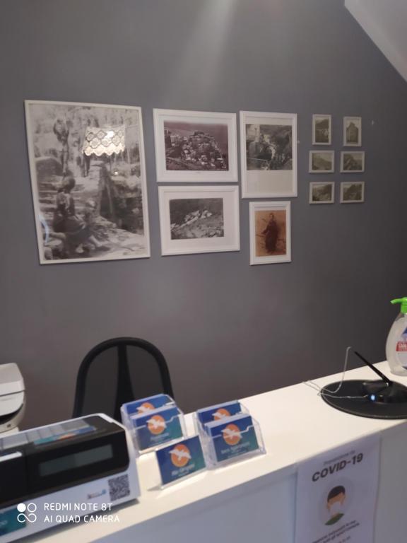 a desk with pictures on the wall and a table with a printer at Rio Groppo Guesthouse in Manarola