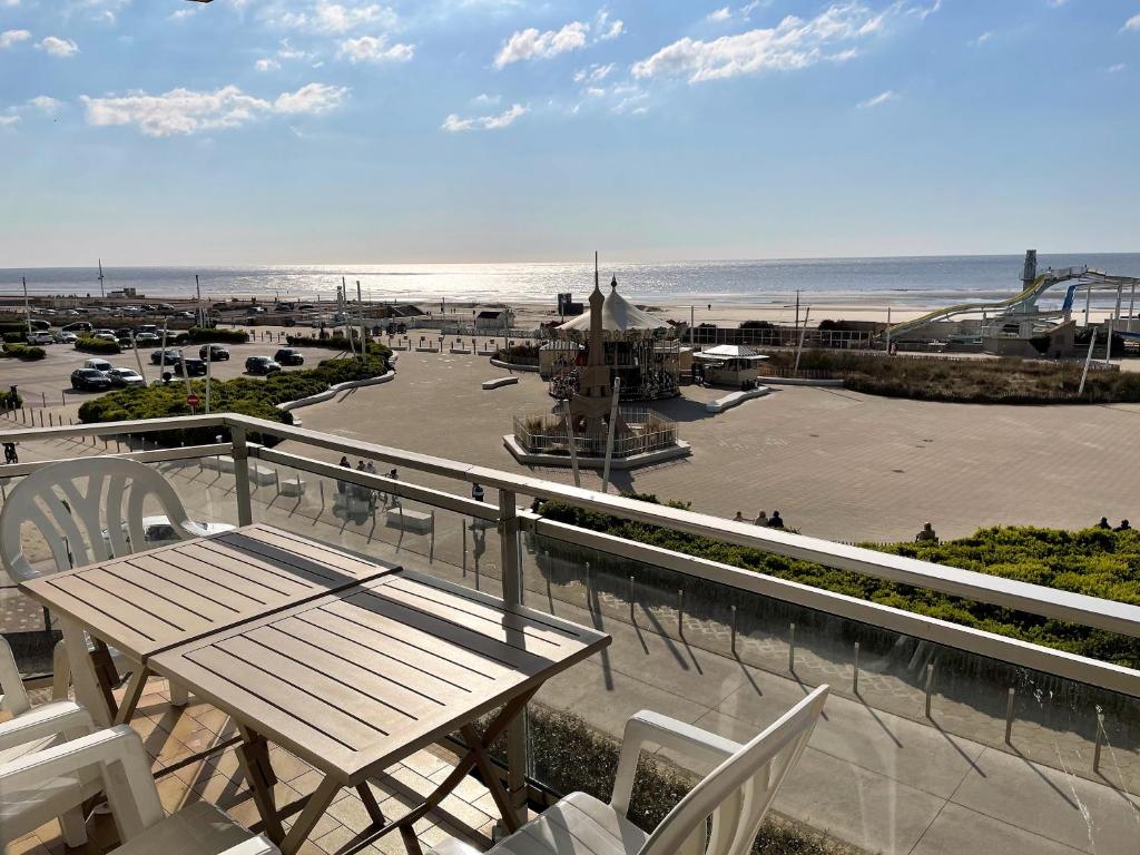 - un balcon avec une table et des chaises et la plage dans l'établissement T2 cabine traversant vue front de mer Le Touquet Paris-Plage, à Le Touquet-Paris-Plage
