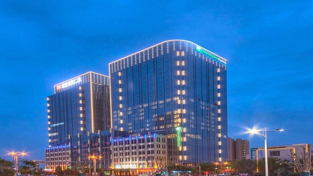 ein hohes Gebäude mit Lichtern in einer Stadt in der Unterkunft Holiday Inn Express Panjin Downtown, an IHG Hotel in Panjin