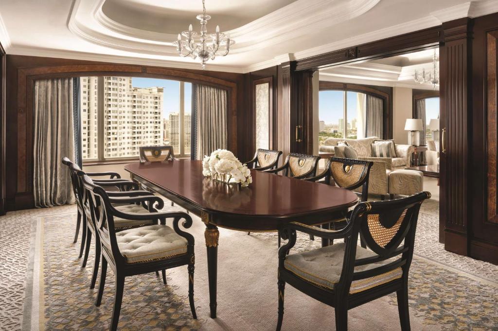 a dining room with a table and chairs and a living room at Shangri-La Jakarta in Jakarta