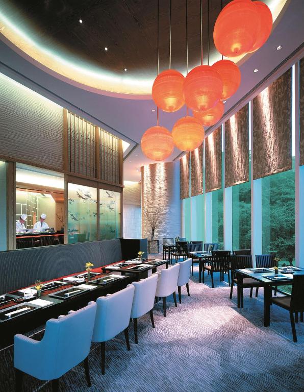 a dining room with tables and chairs and lights at Island Shangri-La, Hong Kong in Hong Kong
