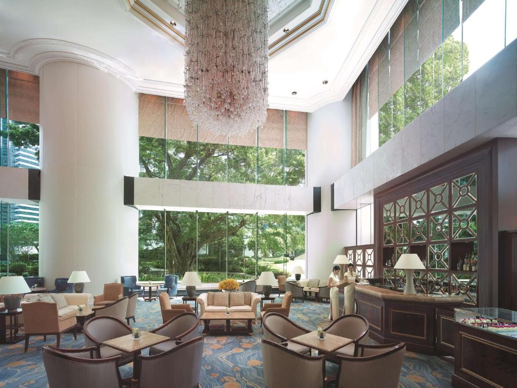 a lobby with tables and chairs and a chandelier at Island Shangri-La, Hong Kong in Hong Kong