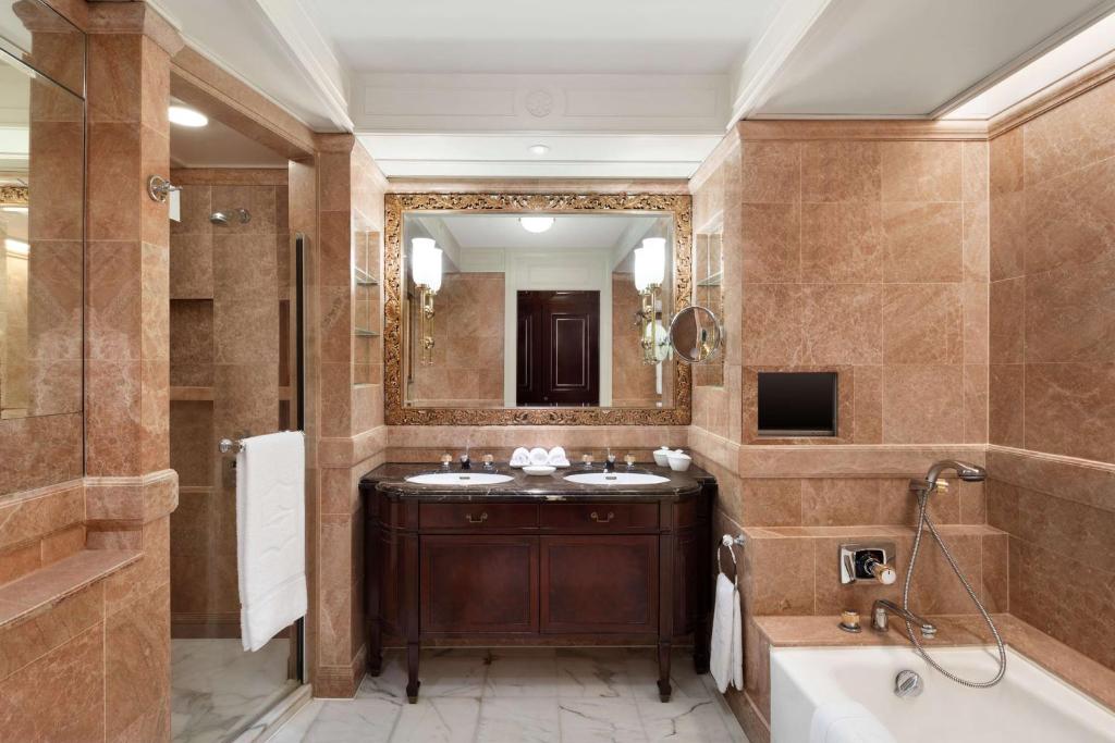 a bathroom with two sinks and a tub and a mirror at Island Shangri-La, Hong Kong in Hong Kong
