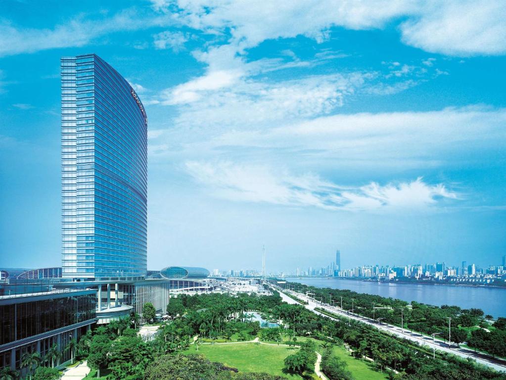 a tall building next to a river and a city at Shangri-La Guangzhou（300 metres walking distance from the Canton Fair Complex） in Guangzhou