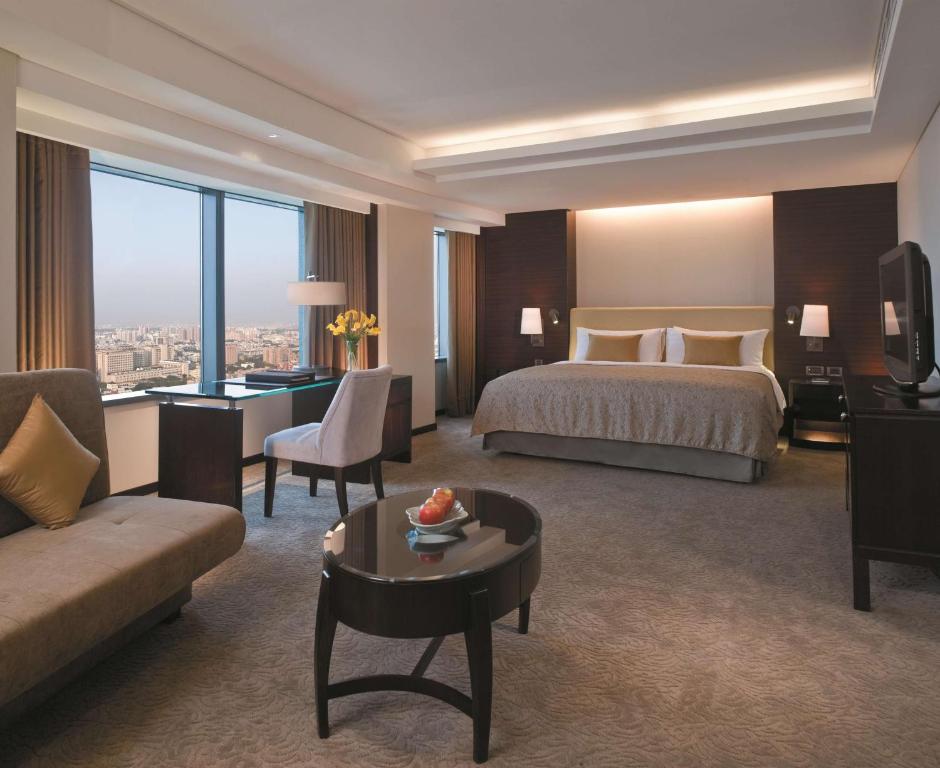 a hotel room with a bed and a living room at Shangri-La Far Eastern Tainan in Tainan