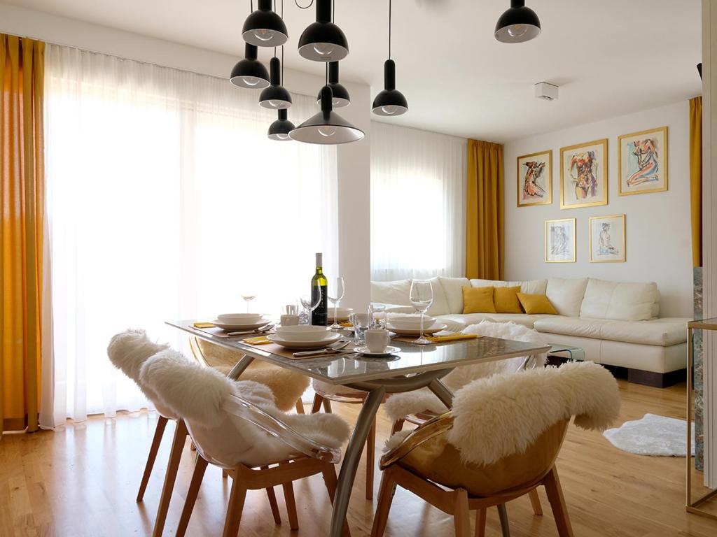 un soggiorno con tavolo, sedie e divano di Apartman No 12 a Mali Lošinj (Lussinpiccolo)