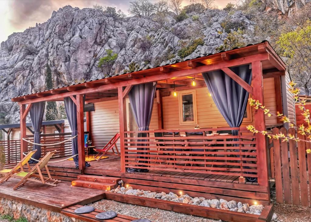 a wooden cabin with a mountain in the background at Mobile Home Rock 'n' Sea in Sveti Juraj