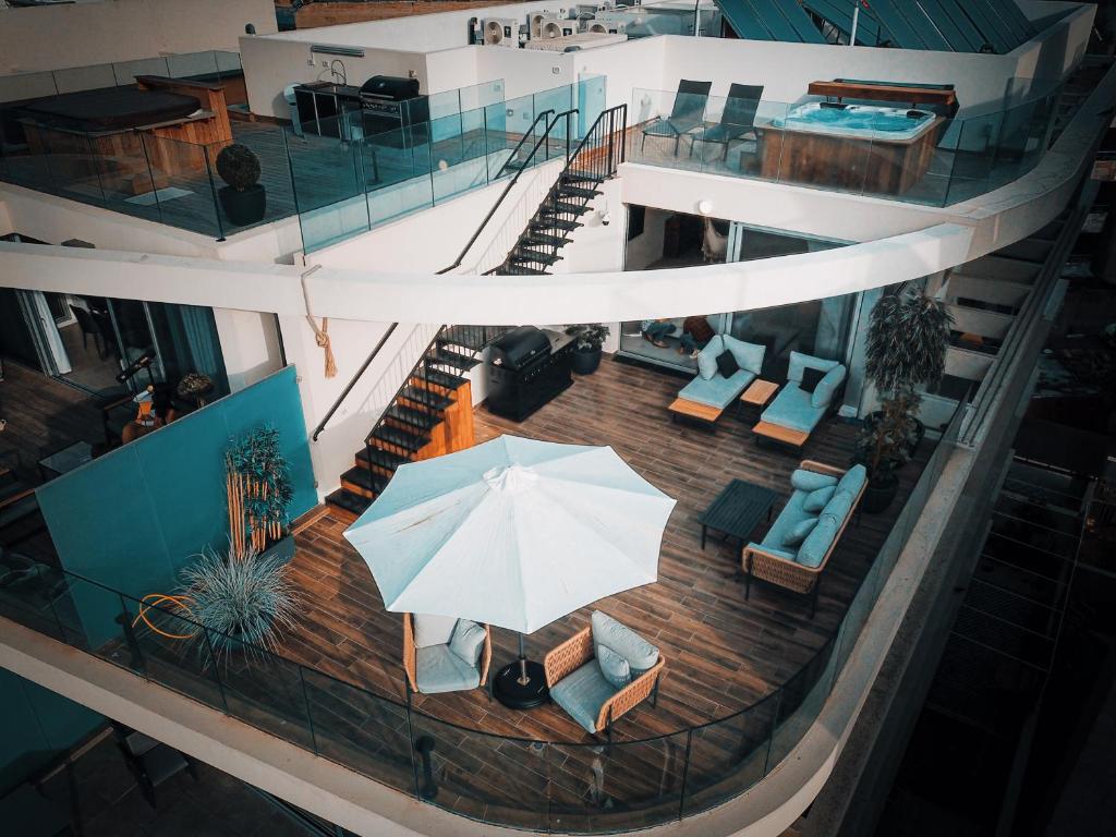 an overhead view of a building with an umbrella and chairs at Dream Penthouse in Haifa