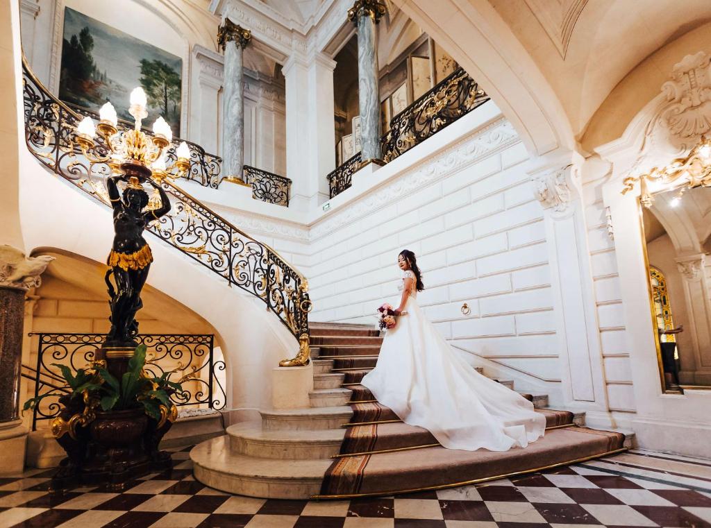 a bride walking down the stairs of a mansion at Shangri-La Paris in Paris