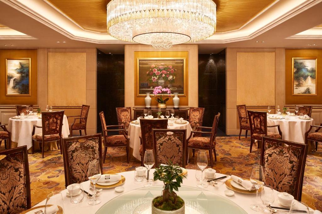a dining room with tables and chairs and a chandelier at Shangri-La Paris in Paris