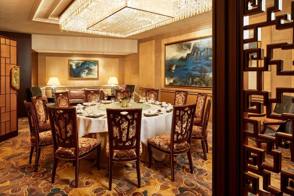 a dining room with a table and chairs and a painting at Shangri-La Paris in Paris