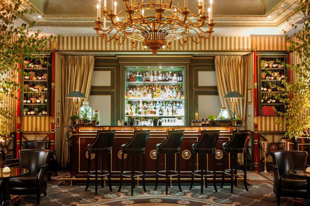 a bar with chairs and a chandelier at Shangri-La Paris in Paris