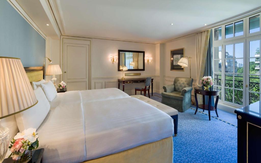 a hotel room with a large bed and a desk at Shangri-La Paris in Paris