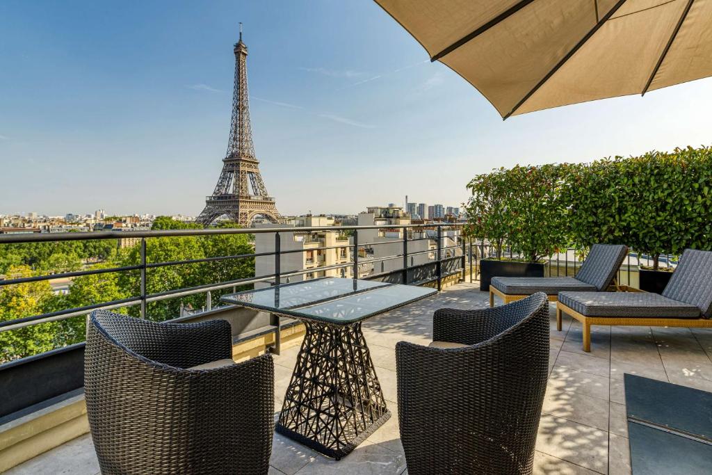 a table and chairs on a balcony with the eiffel tower at Shangri-La Paris in Paris