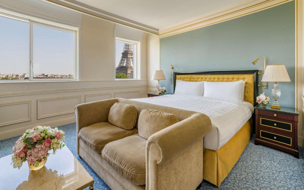 a bedroom with a bed and a couch and a chair at Shangri-La Paris in Paris
