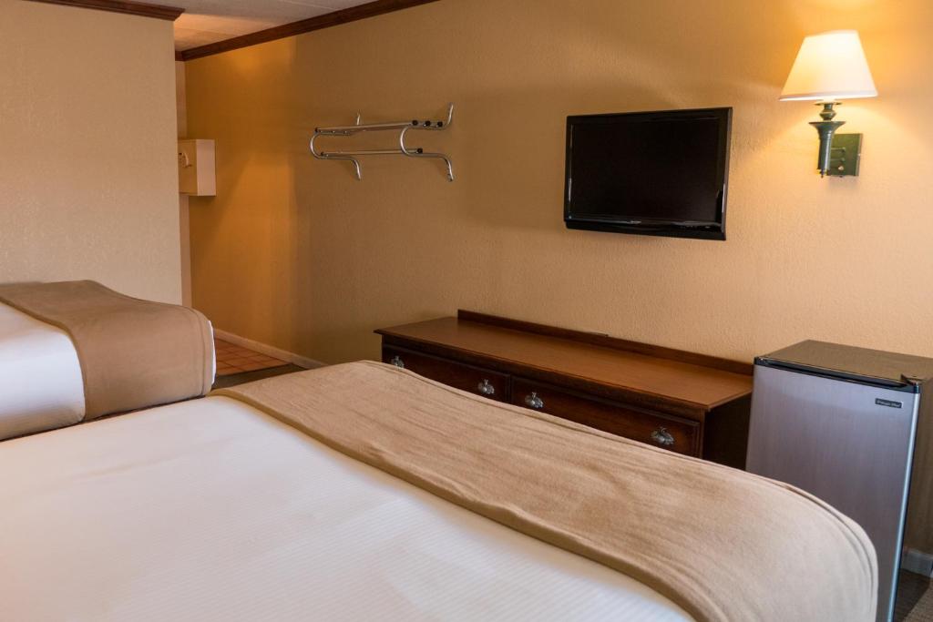 a hotel room with two beds and a flat screen tv at Wild Bear Inn in Pigeon Forge