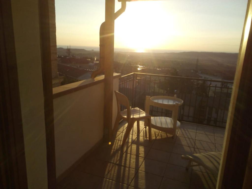 a balcony with two chairs and the sun setting at Il Viandante in Recanati