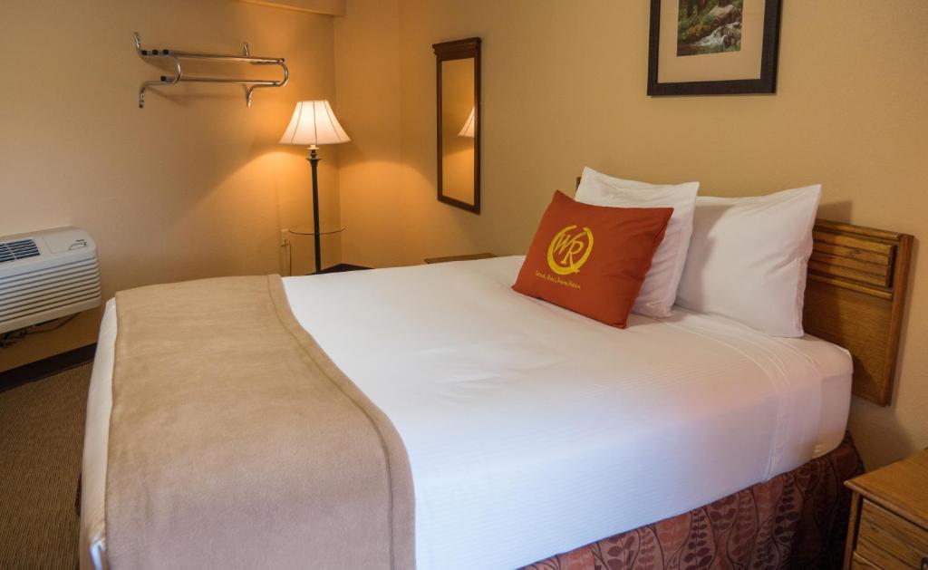 a hotel room with a large white bed with a pillow at Wild Bear Inn in Pigeon Forge