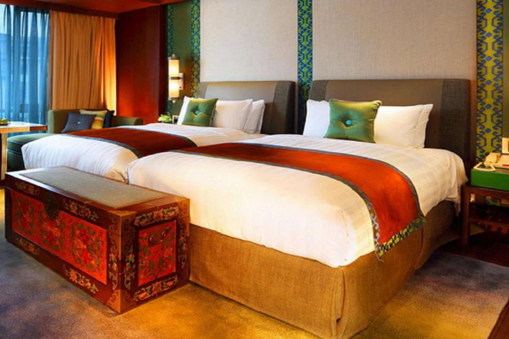 Shangri-La Lhasa في لاسا: سريرين كبيرين في غرفة الفندق