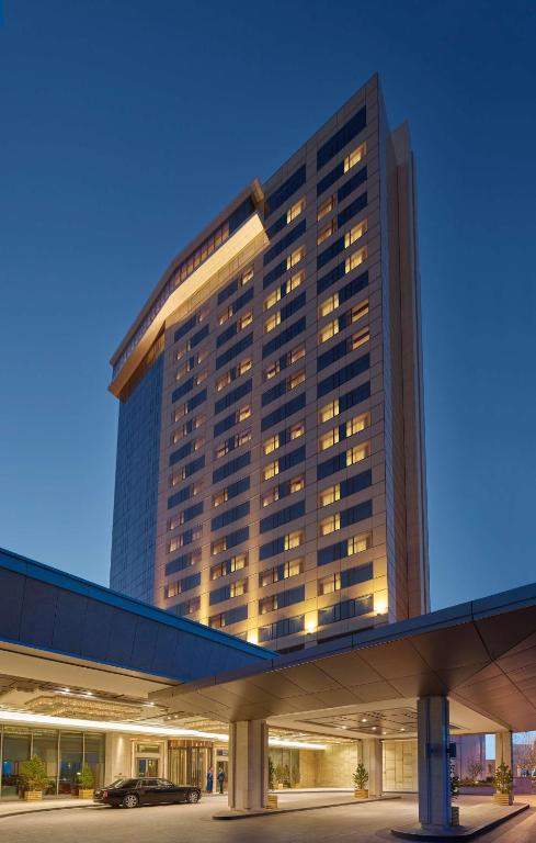 a tall building with lights on in a parking lot at Shangri-La Ulaanbaatar in Ulaanbaatar