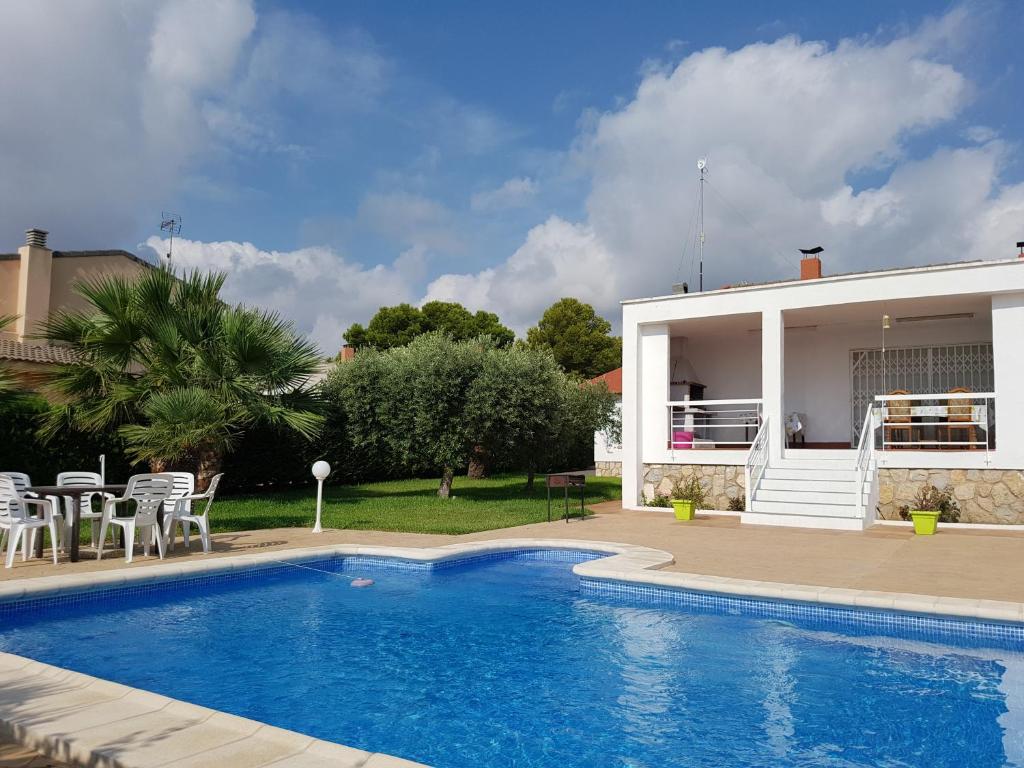 a villa with a swimming pool in front of a house at CAL41 in Calafat