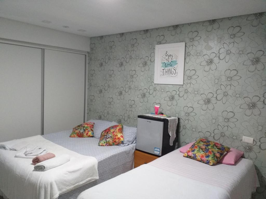 a room with two beds and a tv in it at Quarto TRIPLO CONFORTAVEL E AMPLO NO BAIRRO DO ESPINHEIRO em RECIFE in Recife