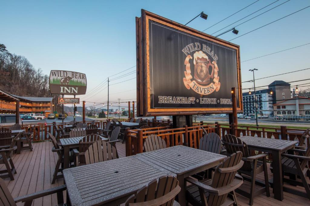 a large sign on a patio with tables and chairs at Wild Bear Inn in Pigeon Forge