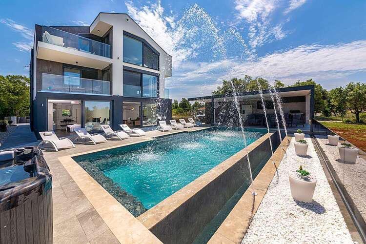 a house with a swimming pool in front of a house at Seaview in Funtana