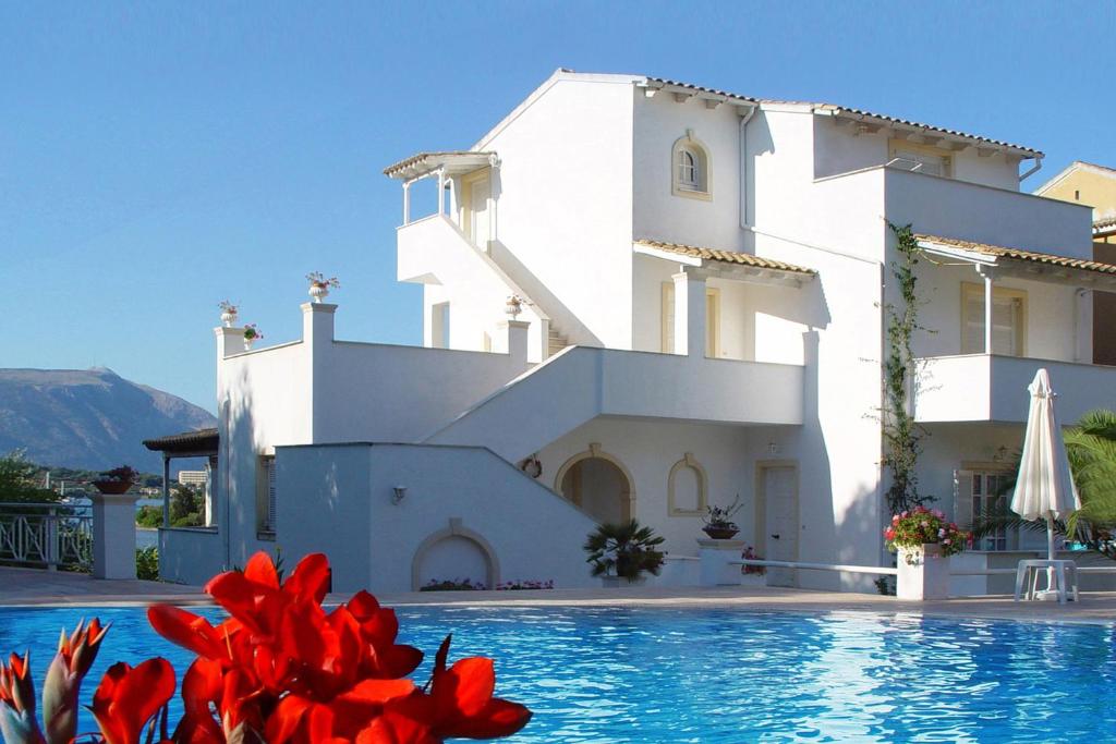 une villa avec une piscine et des fleurs rouges dans l'établissement Maison Metel, à Kontokali