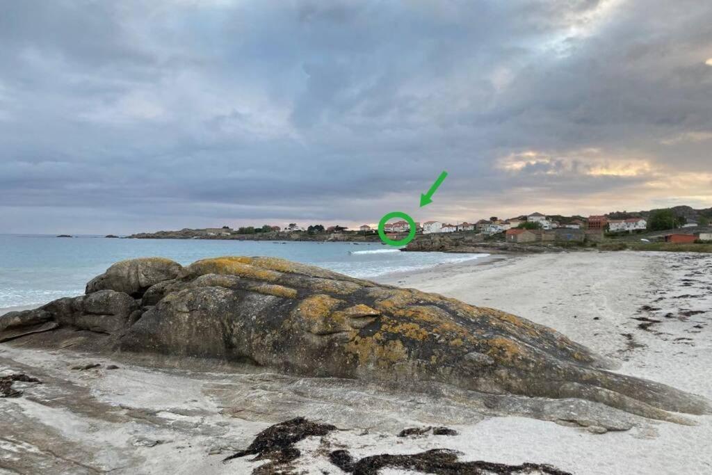 ein großer Felsen am Strand mit Frisbee in der Unterkunft Apartamento con vistas al mar, playa de Carnota! in San Mamede de Carnota