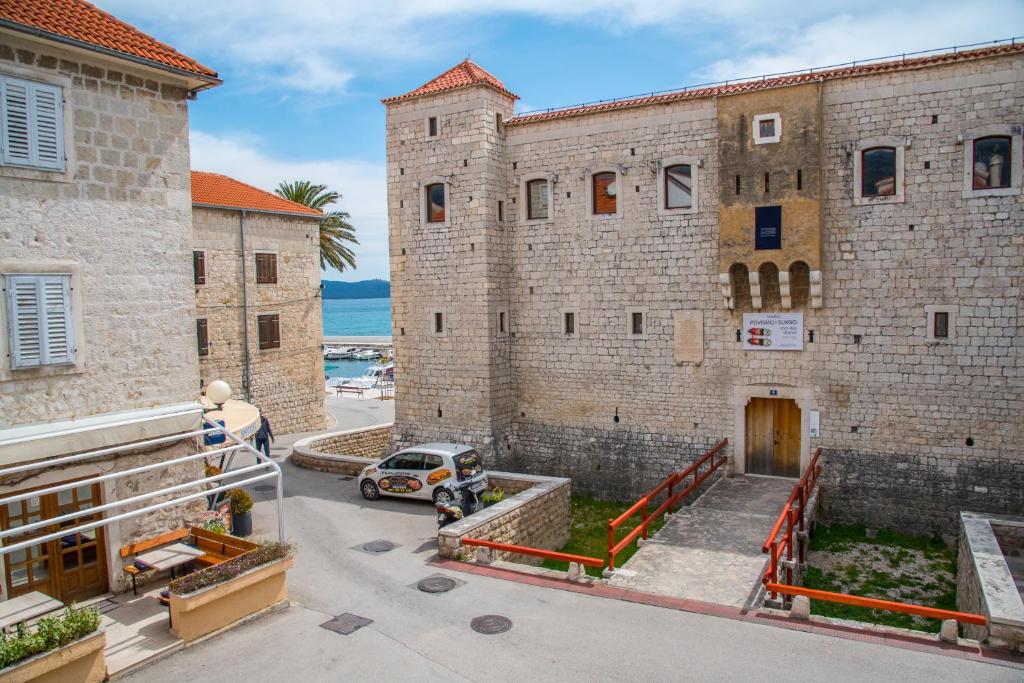 un bâtiment avec une voiture garée devant lui dans l'établissement Heritage Villa Vitturi Sea View, à Kaštela