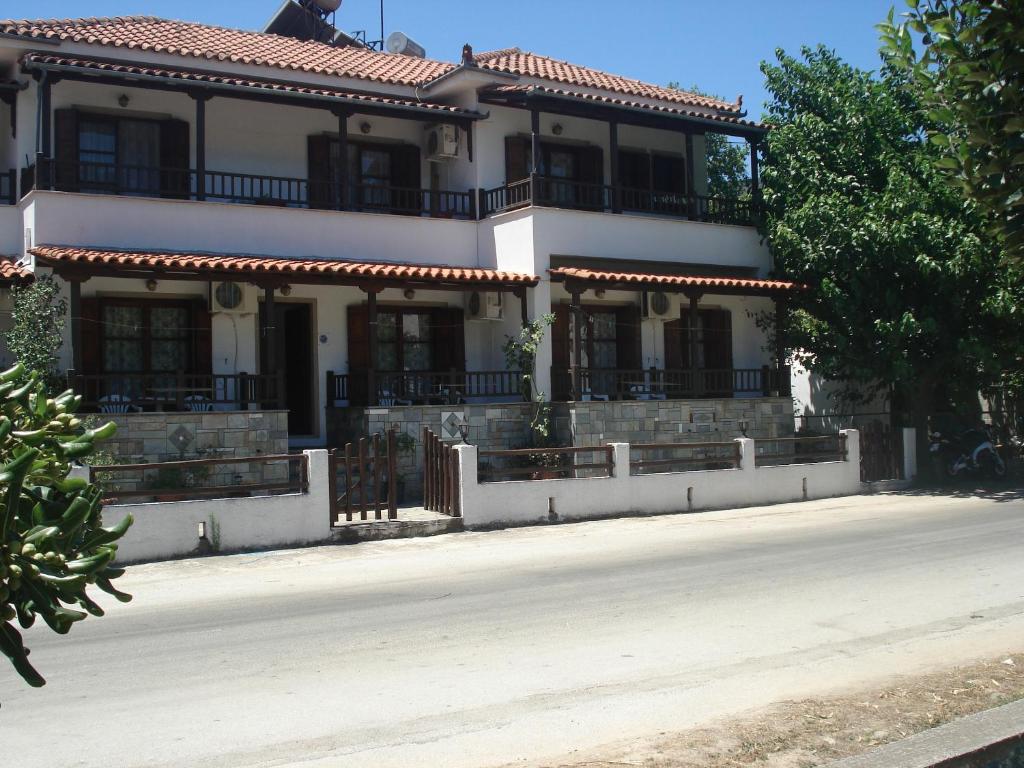 a large white house with a fence in front of it at Tanias House in Platanias