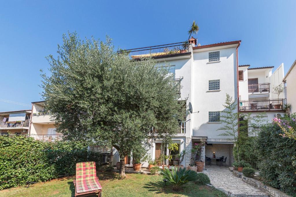 un edificio de apartamentos con un árbol en el patio en Apartments Villa Lungomare, en Pula