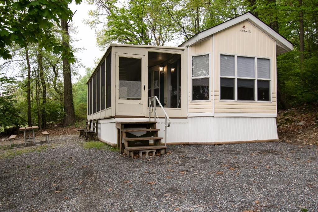 a tiny house sitting on top of a gravel lot at Spring Gulch Screened Park Model 6 in Mount Airy