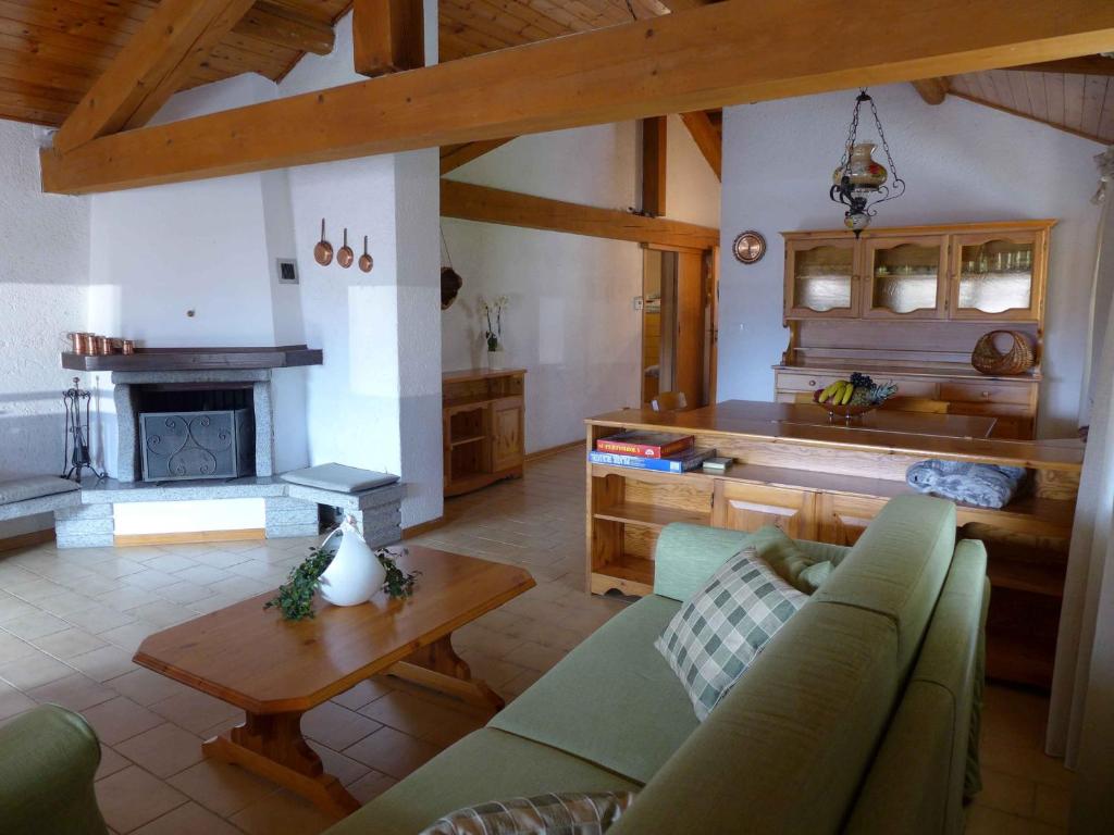 een woonkamer met een bank en een tafel en een keuken bij La Mansarda di nonna Delfa in Pinzolo