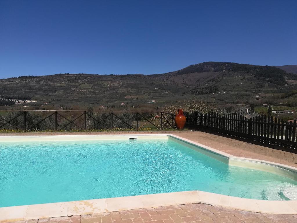 a swimming pool with a mountain in the background at CASALE SAN FORTUNATO in Spello
