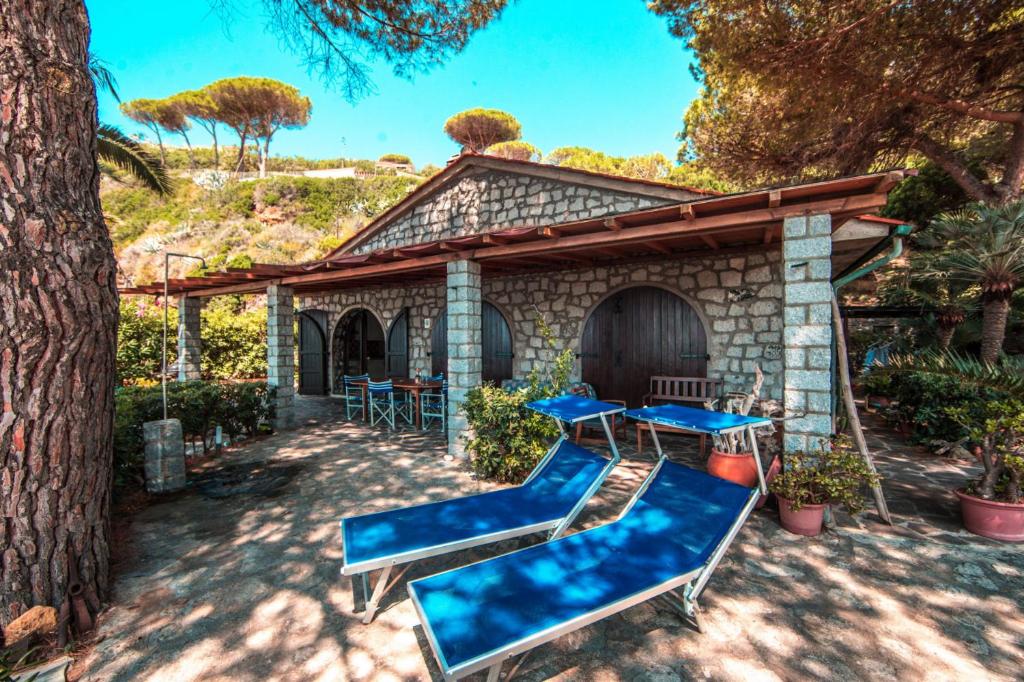 patio z niebieskimi krzesłami i domem w obiekcie Residence Mandel 2 by Mandel Club w mieście Capoliveri