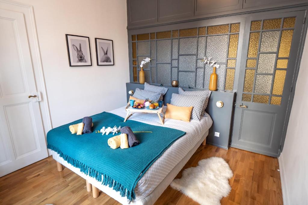 une chambre avec un lit avec une couverture bleue dans l'établissement L'Idéal - 2 pièces en hypercentre, à Annecy