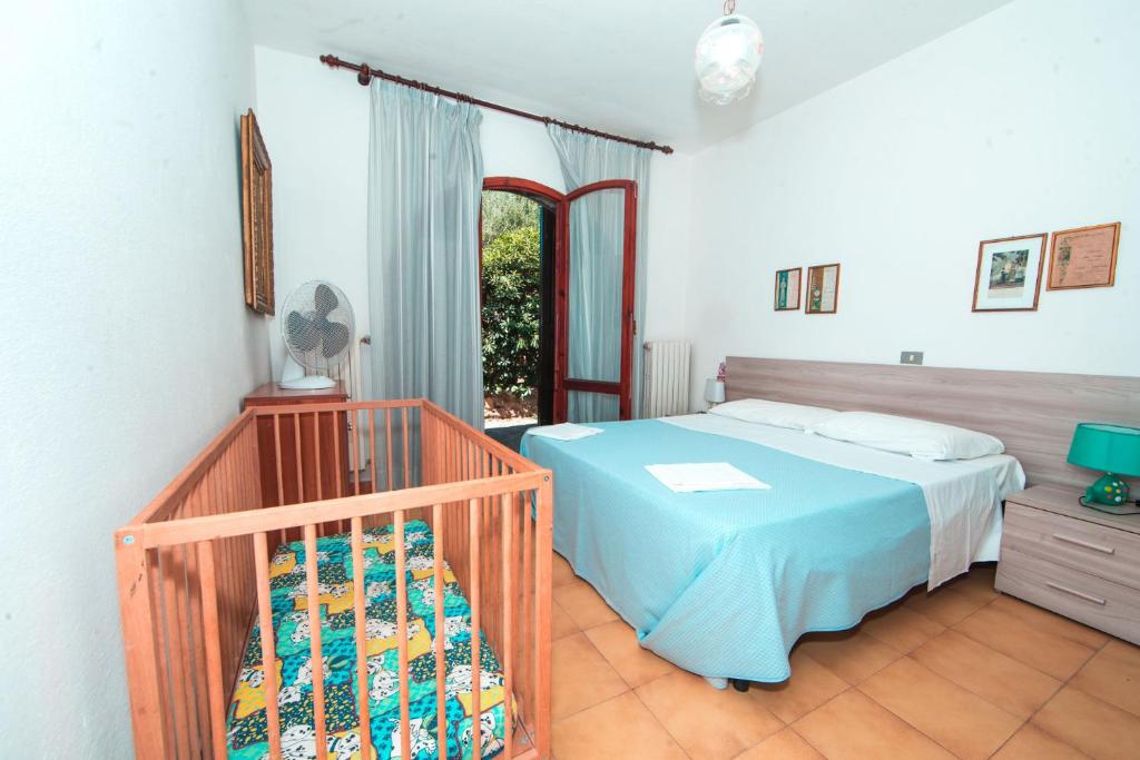 sypialnia z łóżkiem i łóżeczkiem dziecięcym w obiekcie Residence Mandel 2 by Mandel Club w mieście Capoliveri