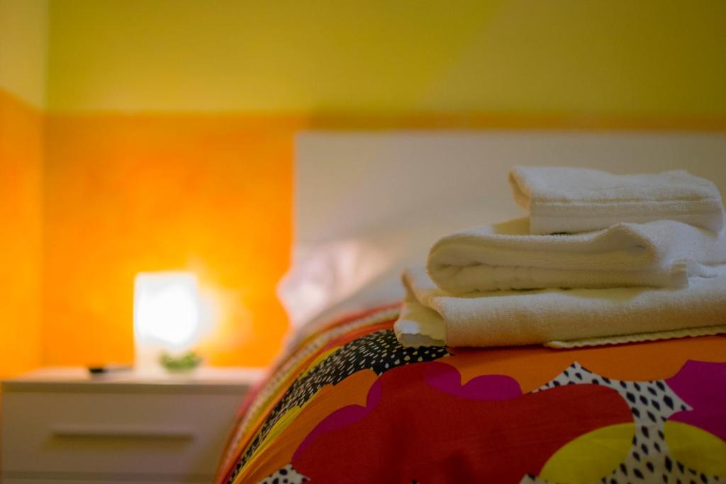 un mucchio di asciugamani seduti sopra un letto di On The Rainbow B&B a Roma