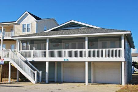 a large house with a porch and two garage at 1 Sand Dollar in Holden Beach