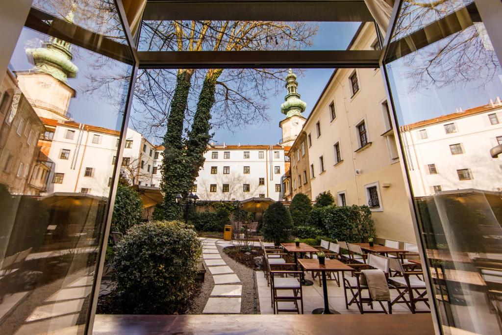 vista su un cortile con tavoli e sedie di BEIGLI Hotel & Garden a Bratislava