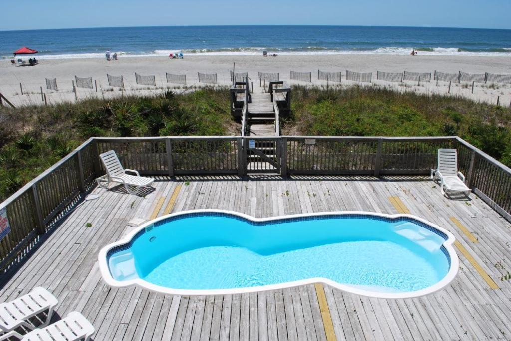 einen Pool auf einer Terrasse neben dem Strand in der Unterkunft Bikini Bottom in Holden Beach