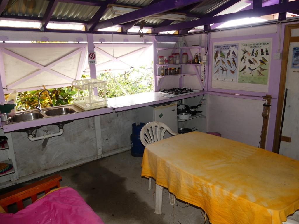 una cucina con tavolo, lavandino e finestra di Tikaz Toukité a Méro