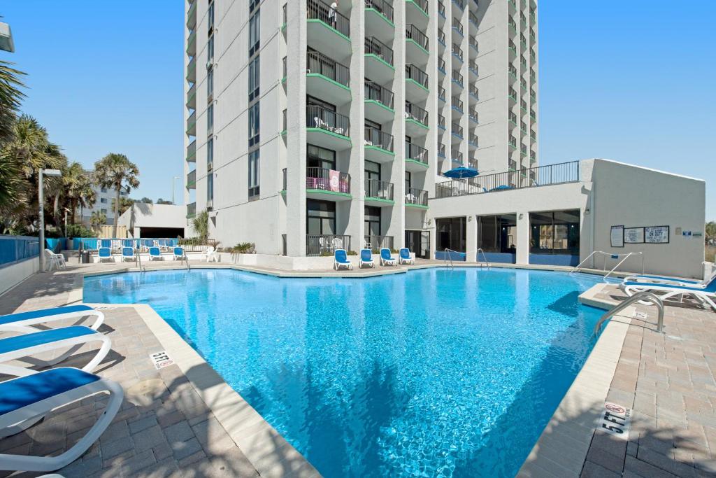 默特尔比奇Ocean Park Resort - Oceana Resorts Vacation Rentals的一个带椅子的大型游泳池和一栋建筑